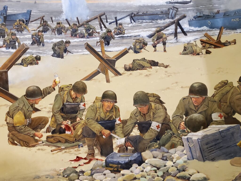 In this intense scene medics treat wounded on Omaha Beach.